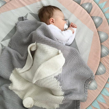 Cette couverture tricotée en coton et fibres de bambou mélangées avec son adorable motif lapin fera fureur cet hiver!