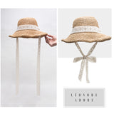 Соломенная пляжная шляпа на ветру, которая не боится Мистраля благодаря своей красивой ленте.